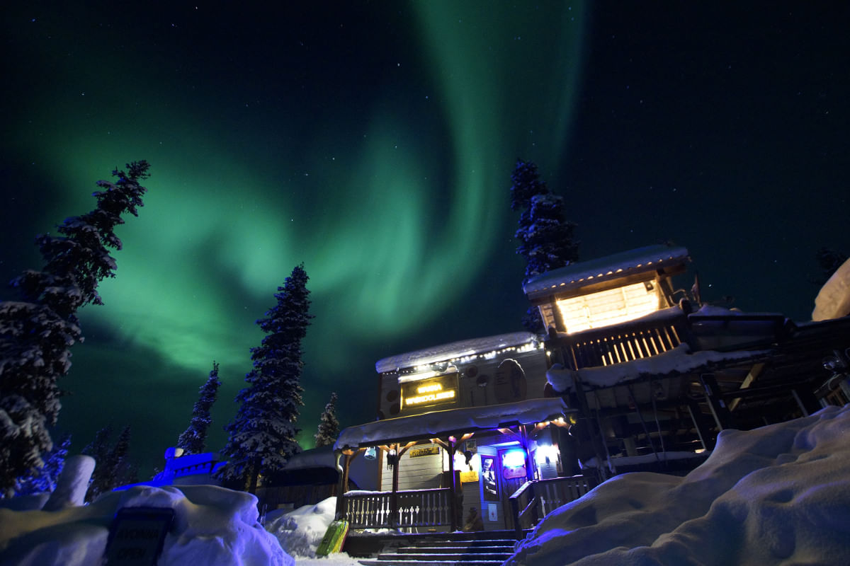 Northern lights on sky above the main building of the Tankavaara Gold Village
