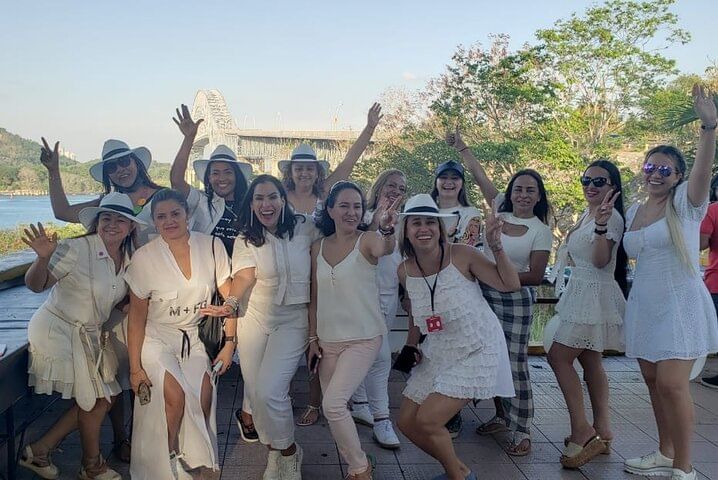 Turistas posando frente al Puente de las Américas durante un recorrido privado o en grupo pequeño de medio día por el Canal de Panamá y la ciudad
