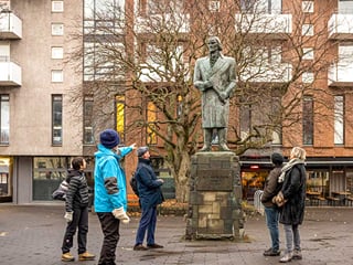A guide from Your Friend in Reykjavik explaining the statue to a group.