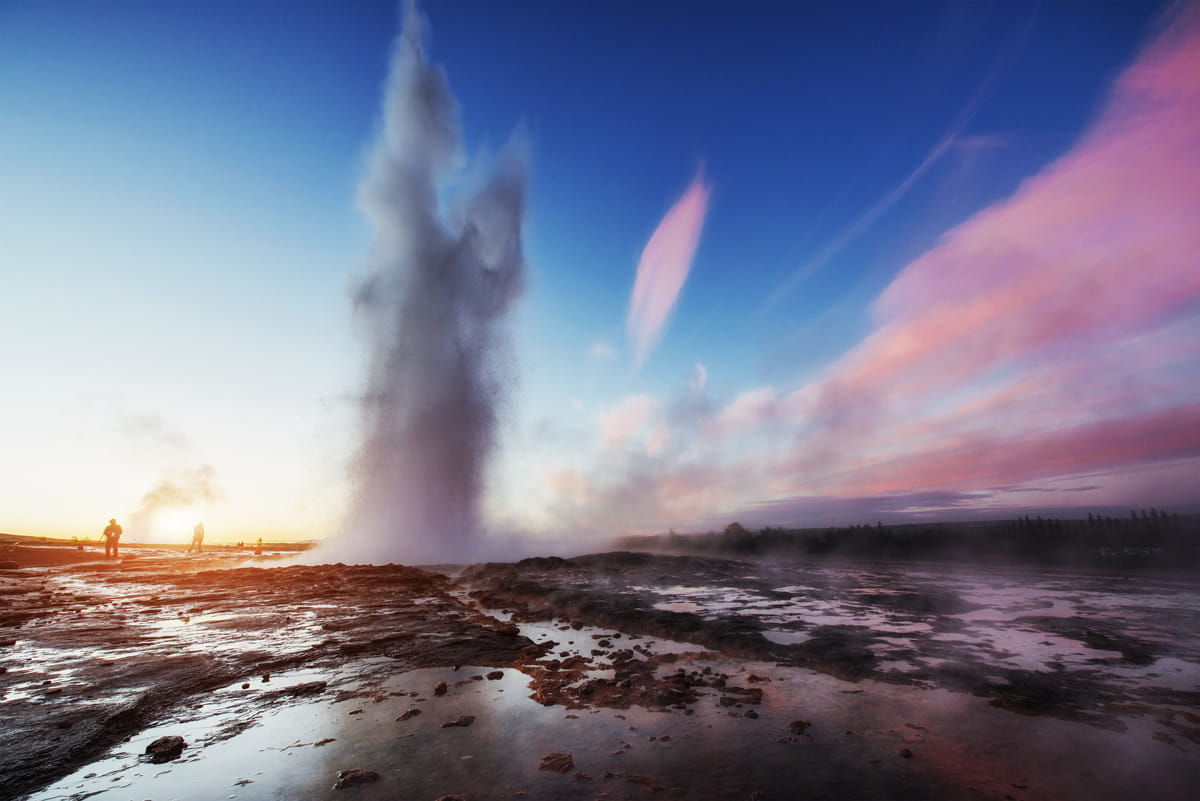 Geyser erupting in the sunset