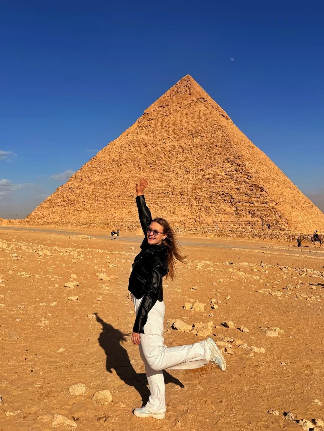 Tourists standing in front of the Khafre Pyramid, smiling and taking photos during a private Egypt tour, with the pyramid’s limestone casing