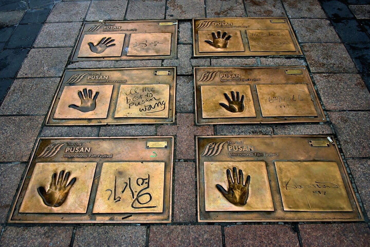 Bronze movie star handprints embedded in the pavement at BIFF Square.