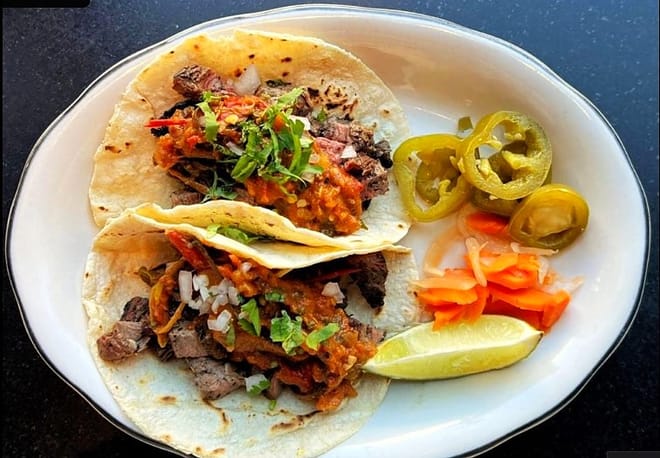 Authentic Mexican steak tacos with salsa, lime, and jalapeños in Los Cabos