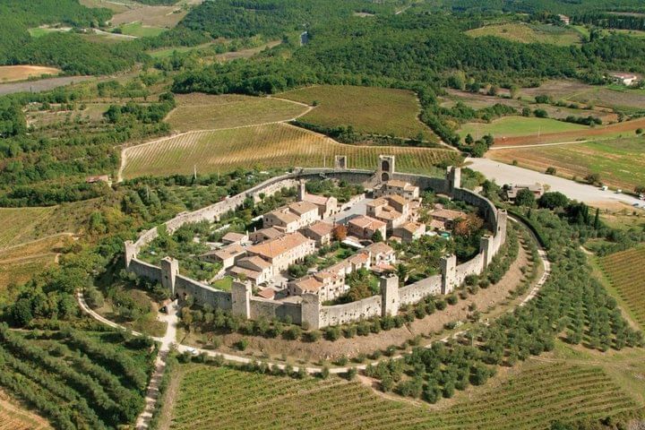 Panoramic view of Monteriggioni with its walls encircling the small town in the Tuscan hills