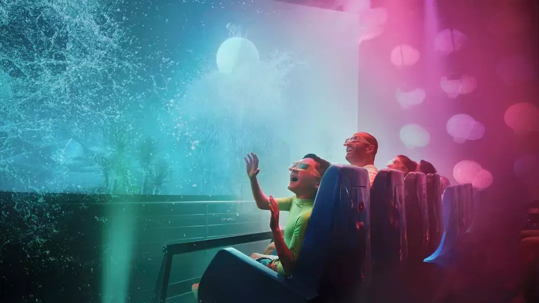 People wearing 3D glasses react with excitement while watching an immersive projection screen at Yas Waterworld, Abu Dhabi.