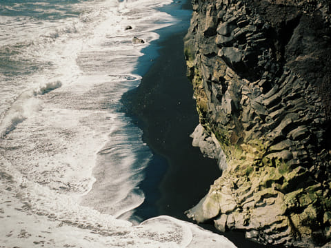 Basalt formations over a black sand beach