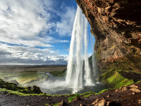 A waterfall plunges from cliffs.