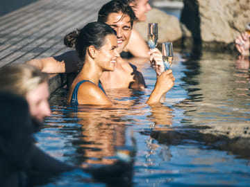 Enjoy a drink in the luxurious Hvammsvik Hot Springs while immersing yourself in this luxurious experience