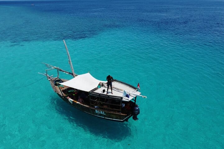 Cruise over Zanzibar’s crystal-blue waters on a traditional boat, soaking in stunning ocean views and island serenity.