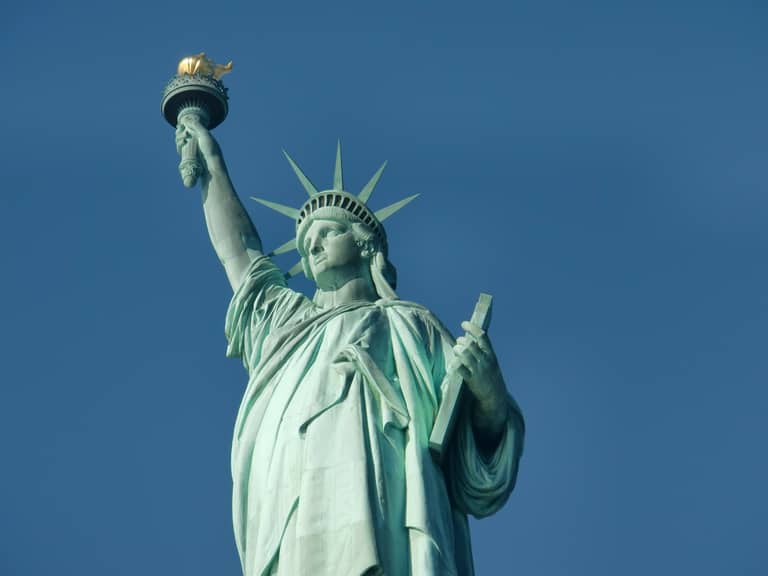 Statue of Liberty torch and crown against clear blue sky in New York Harbor