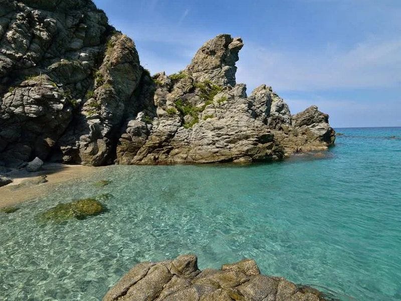 Clear blue sea with rocky cliffs along the Costa Viola coastline