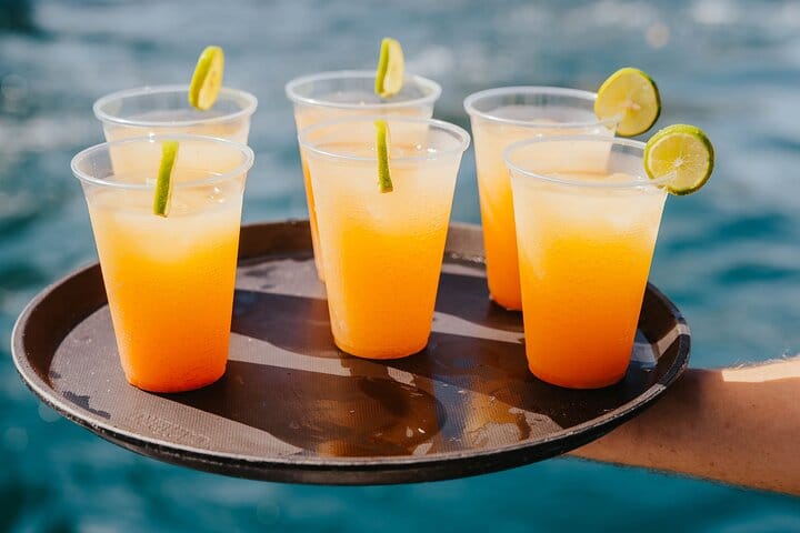 Toast to the sea! Enjoy tropical cocktails with fresh lime while cruising the sparkling waters of Los Cabos on a private catamaran.