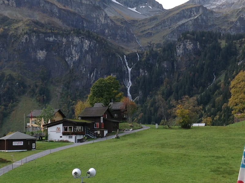 Chalés de Braunwald no outono, com uma cachoeira ao fundo.