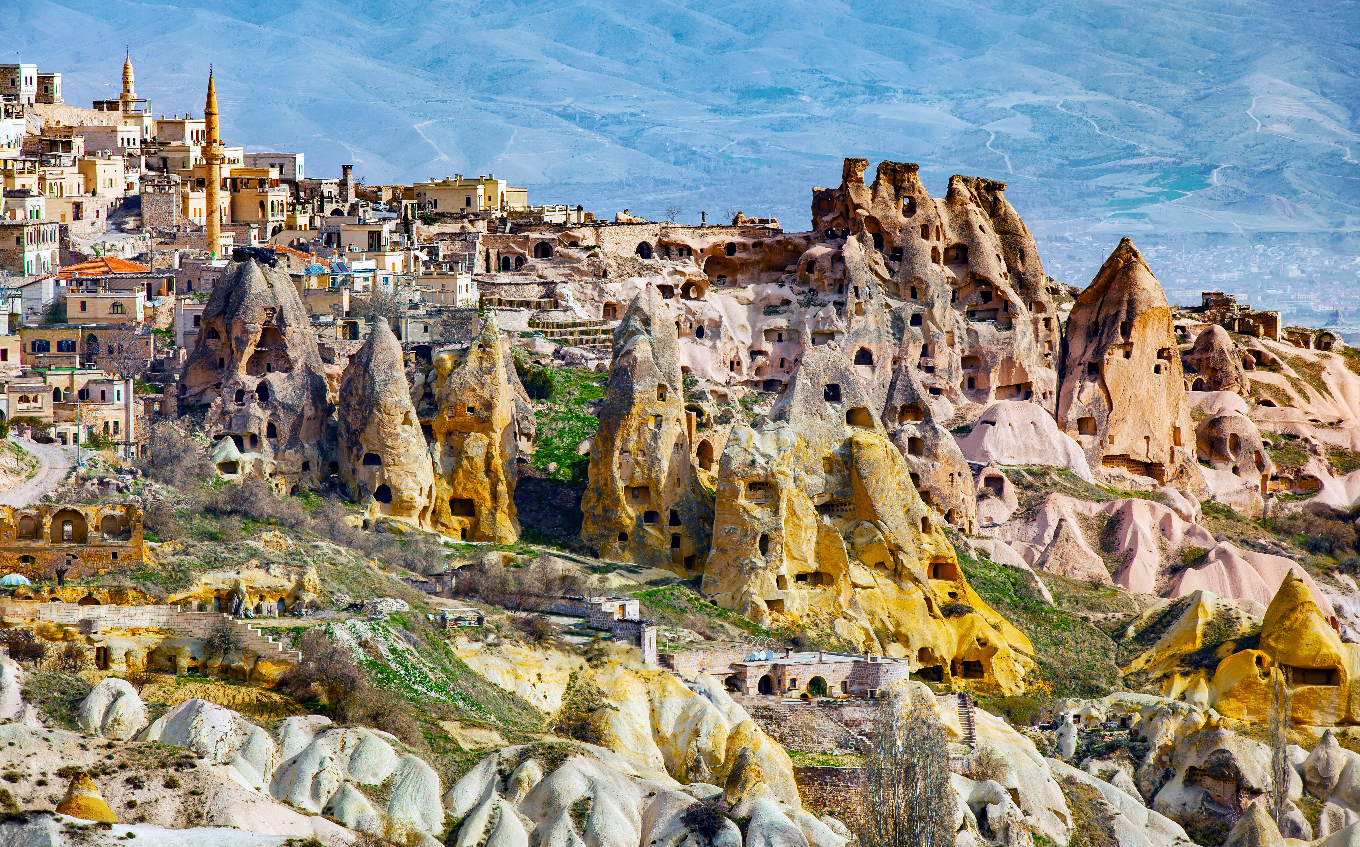 “Panoramic view of Cappadocia’s distinctive rocky mountains and fairy chimneys under a clear blue sky.”