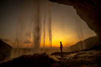 Alone in the world enjoying sunset behind Seljalandsfoss waterfall