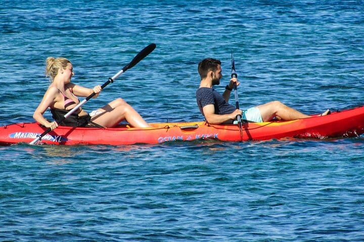 Two paddlers in a tandem kayak on clear Key Largo water
