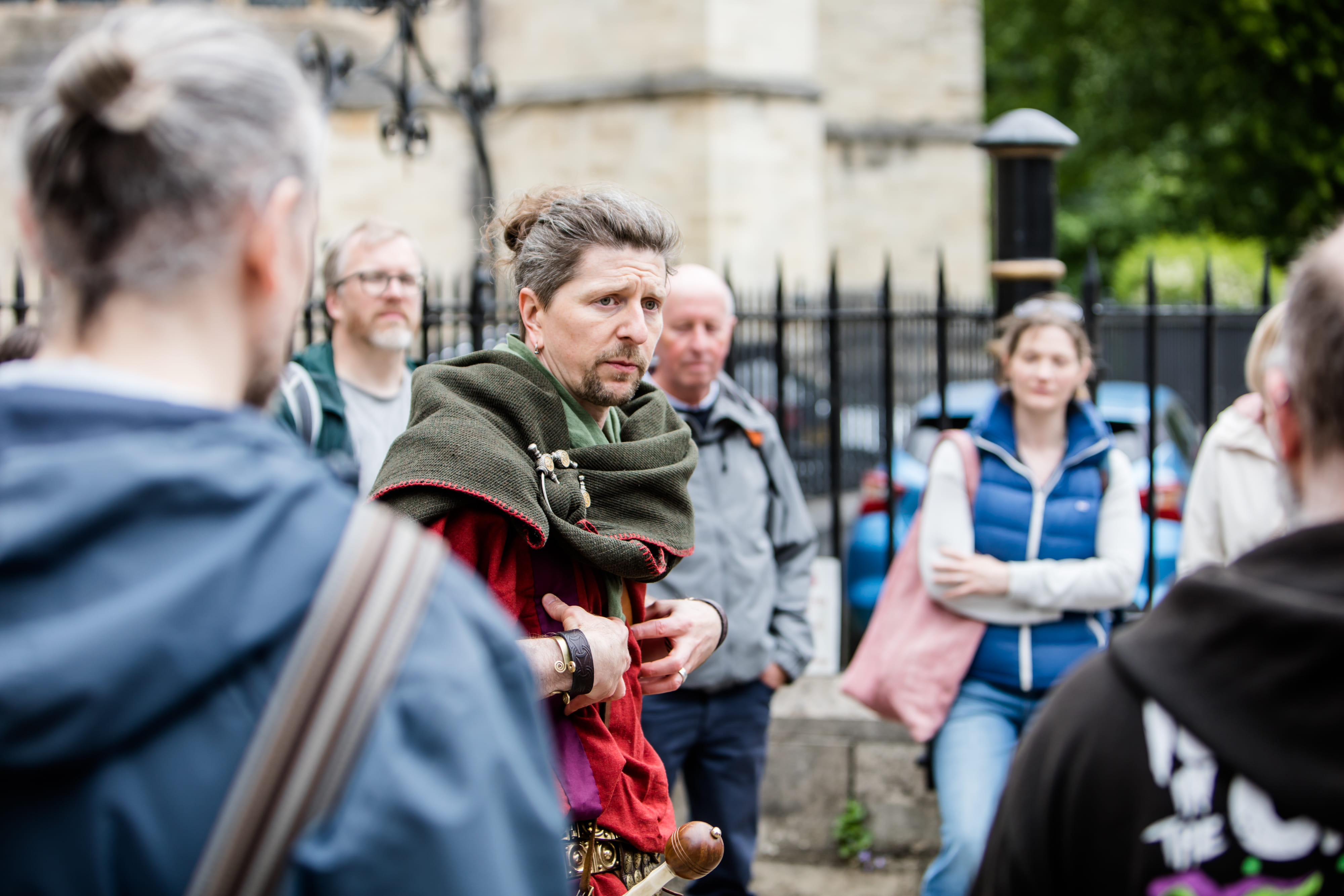 The Original Roman Walk's costumed guide is stood surrounded by guests besides the York Minster (out of frame).