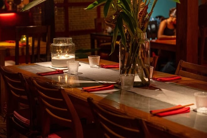 Anticipation builds — A candlelit table awaits guests in our hidden, atmospheric venue.