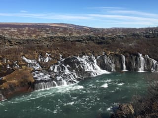 Panoramic view of the waterfall Hraunfoss coming from beneath a lava field