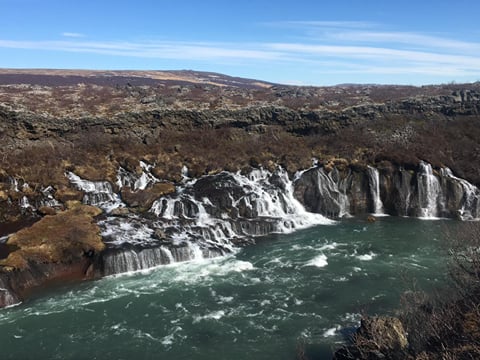 Panoramic view of the waterfall Hraunfoss coming from beneath a lava field
