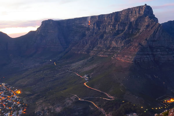 Majestic Table Mountain at twilight with Cape Town city lights below.
