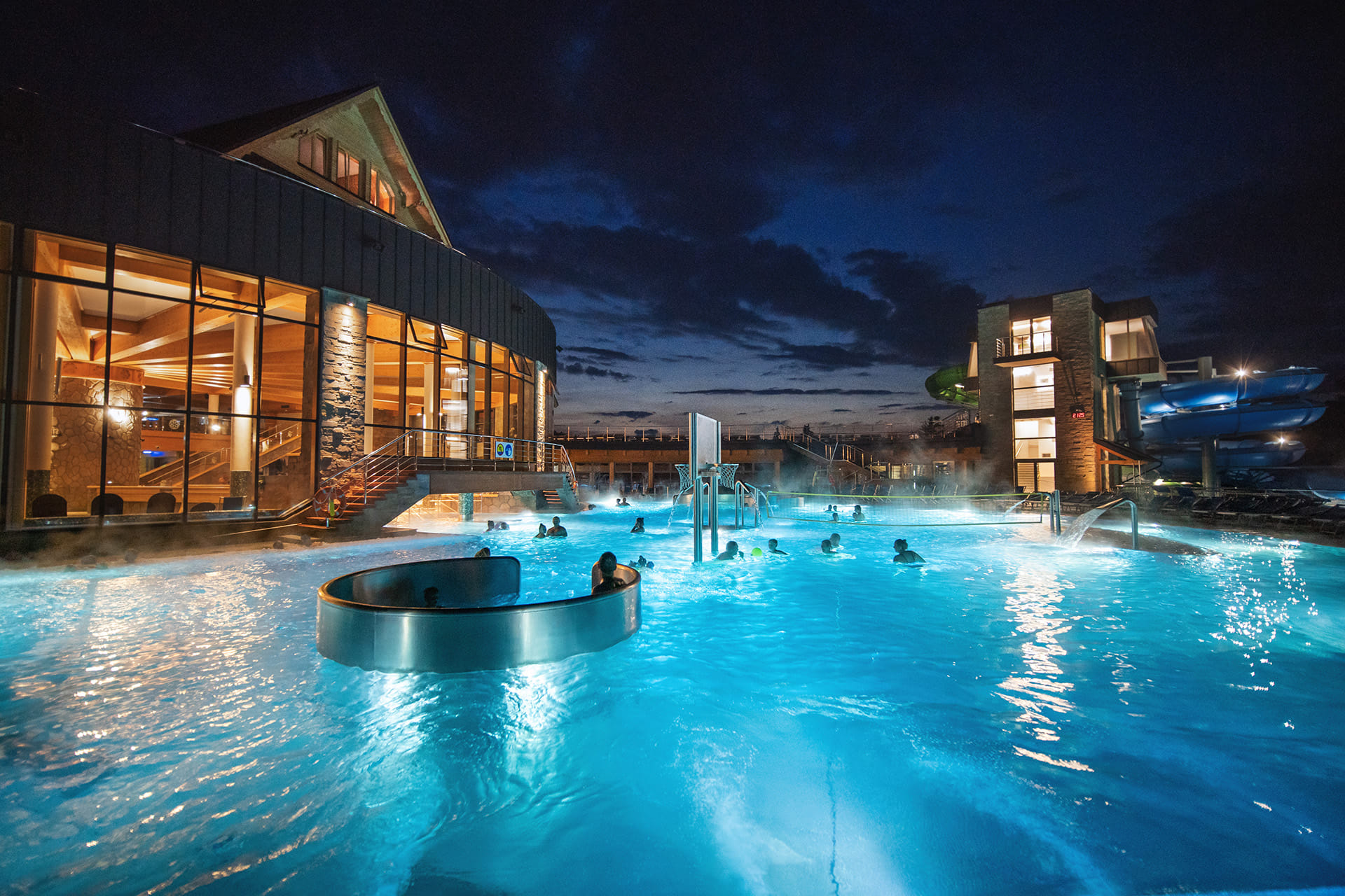 Chochołów Thermal Baths outdoor pool evening — guests relaxing in mineral thermal water near Zakopane