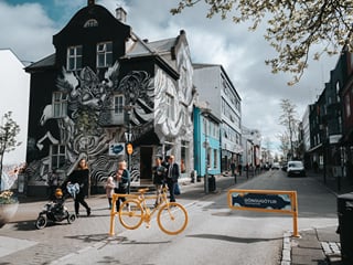 A group of travellers in front of a house that was painted by an artist