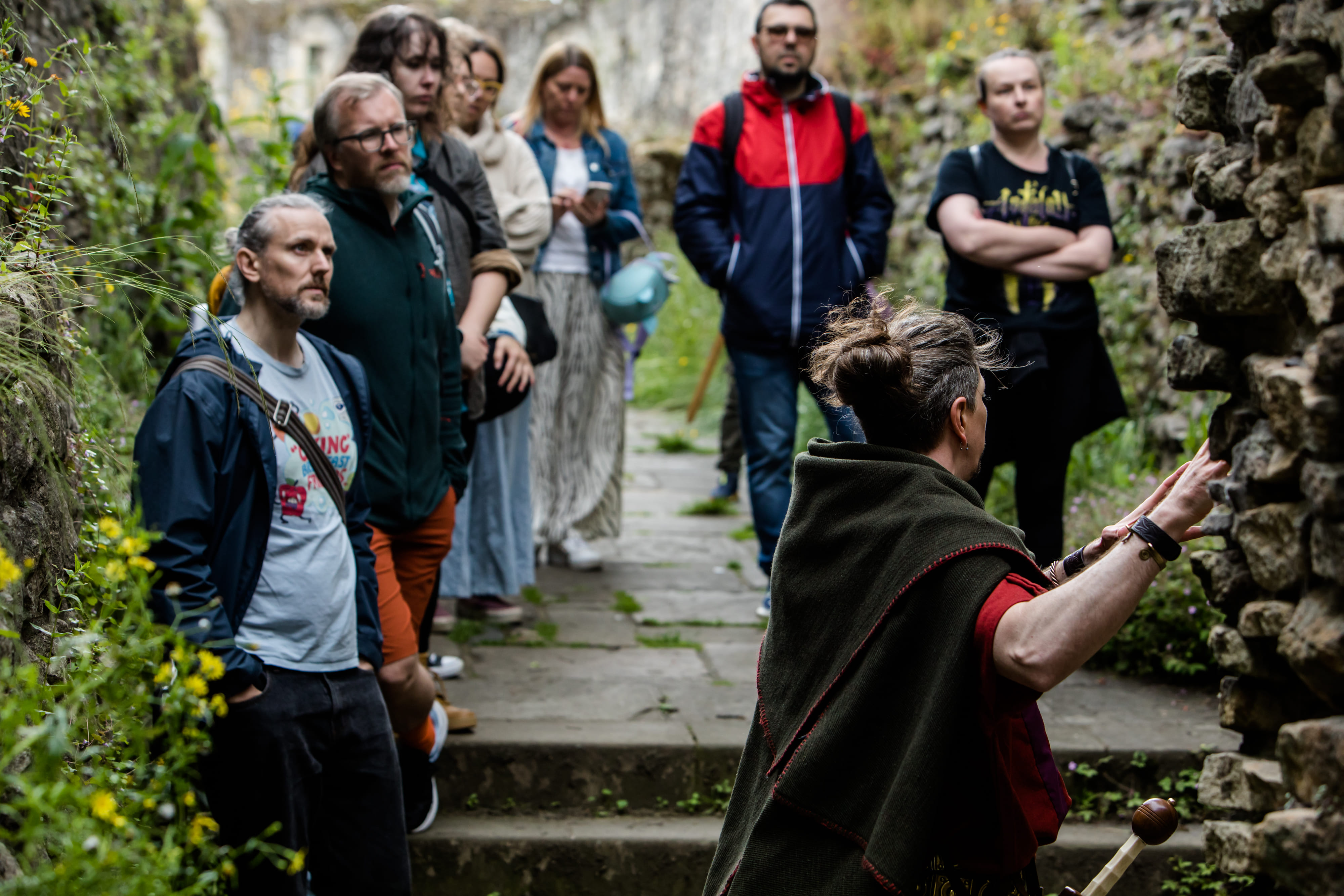 The Original Roman Walk's costumed guide, dressed as a Roman legionary, next to the mis-named Anglian Tower, surrounded by guests.