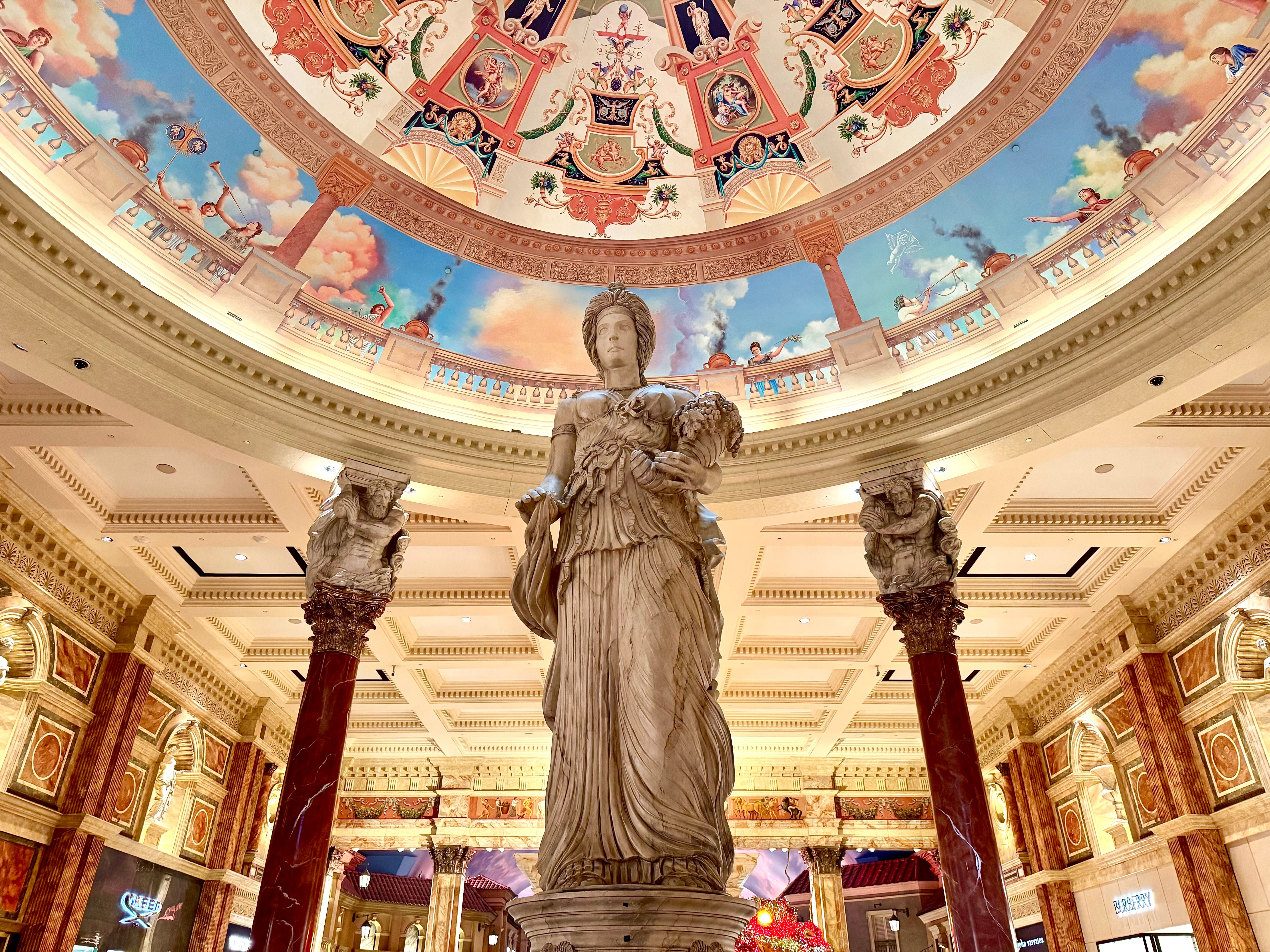 Roman-style statues beneath an ornate painted dome inside the Forum Shops.