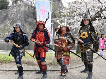 The flower is the cherry tree, The man is the Samurai A famous castle that marks the prosperity & upheavals of the people of Japan.