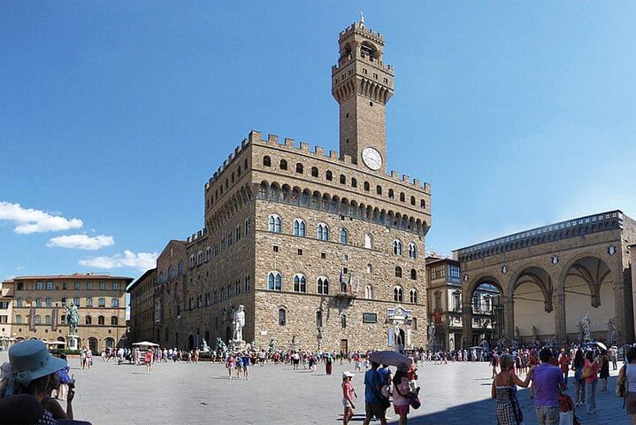 Wide view of Signoria Square with Palazzo Vecchio, the statue of Neptune and the Loggia dei Lanzi on the far right of the picture