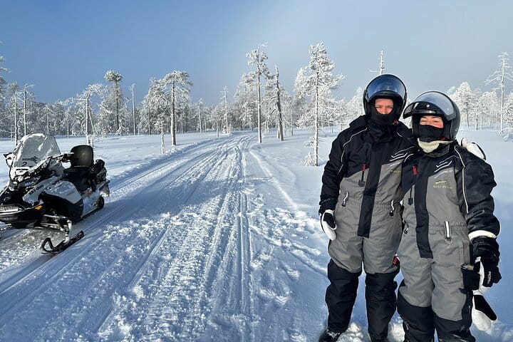 Guests in winter gear after a snowmobile ride for Ice Fishing with Snowmobiles in Rovaniemi with StayLapland.