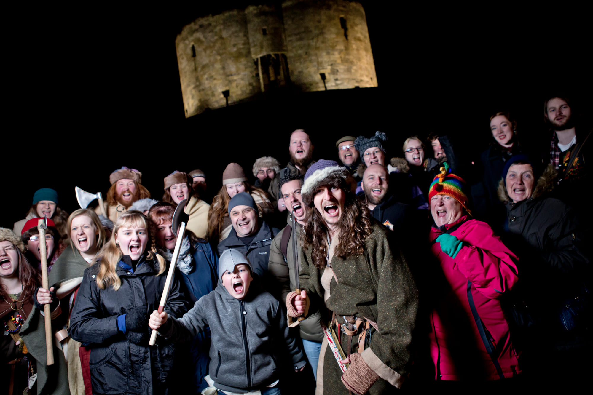 A costumed Viking guide stood in front of Clifford's Tower, a Norman Keep, in York, with a group of guests.