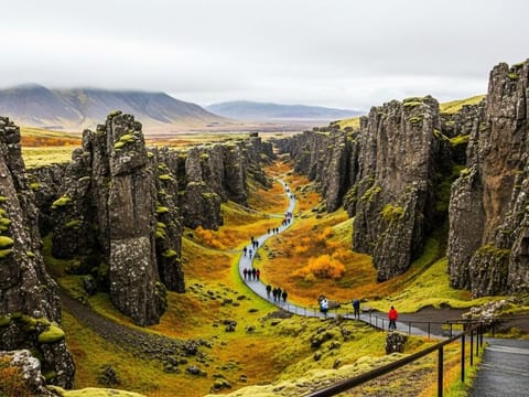 A scenic view of the rift valley at Þingvellir National Park, with a path winding between the tall, rocky cliffs.