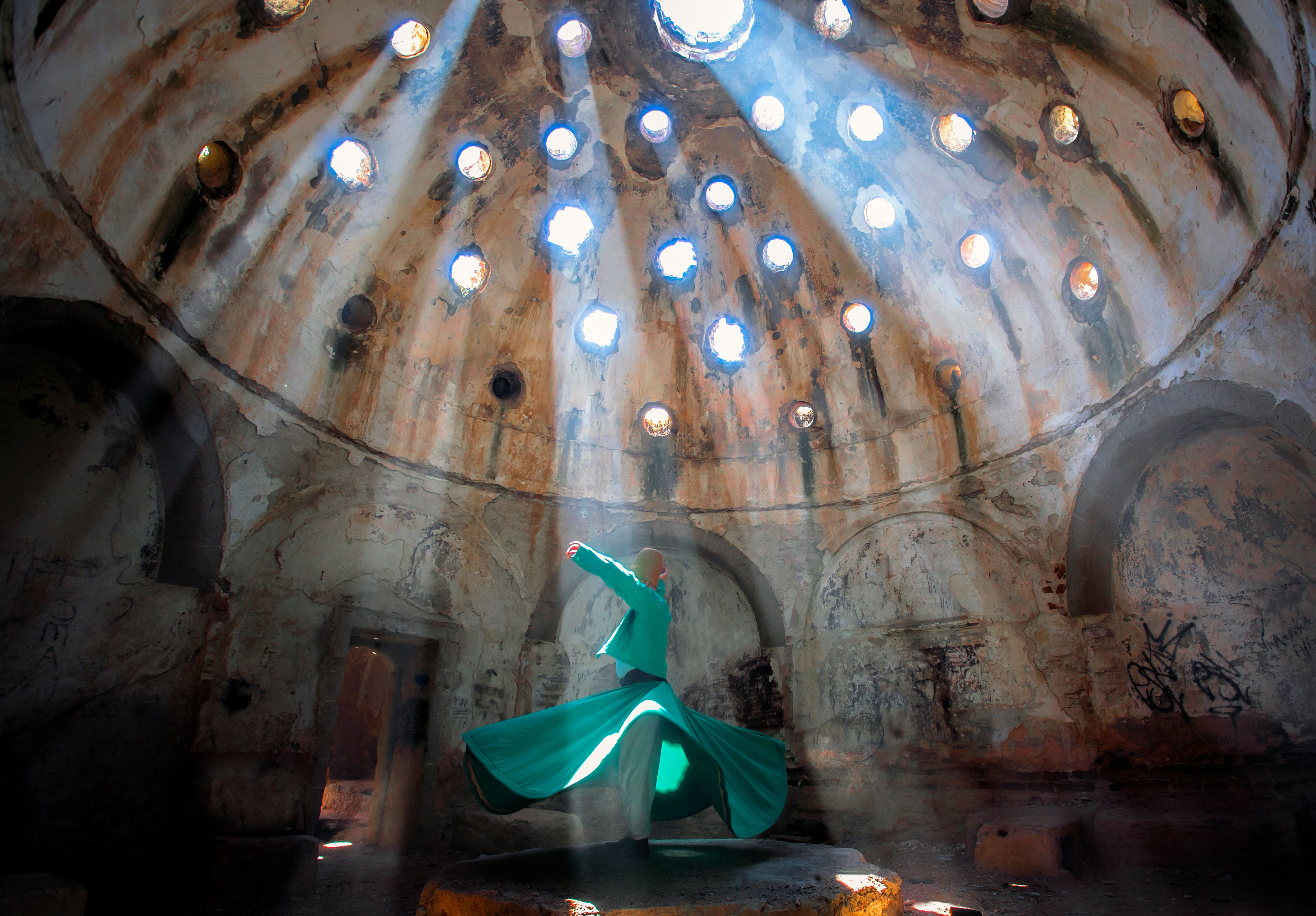 “Whirling Dervishes spinning in a circle wearing bright, colorful robes and traditional hats during a lively Sema ceremony.”