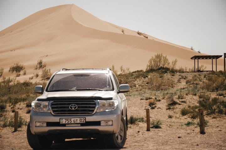 Desert scenery with giant sand dune and mountain background in Kazakhstan.