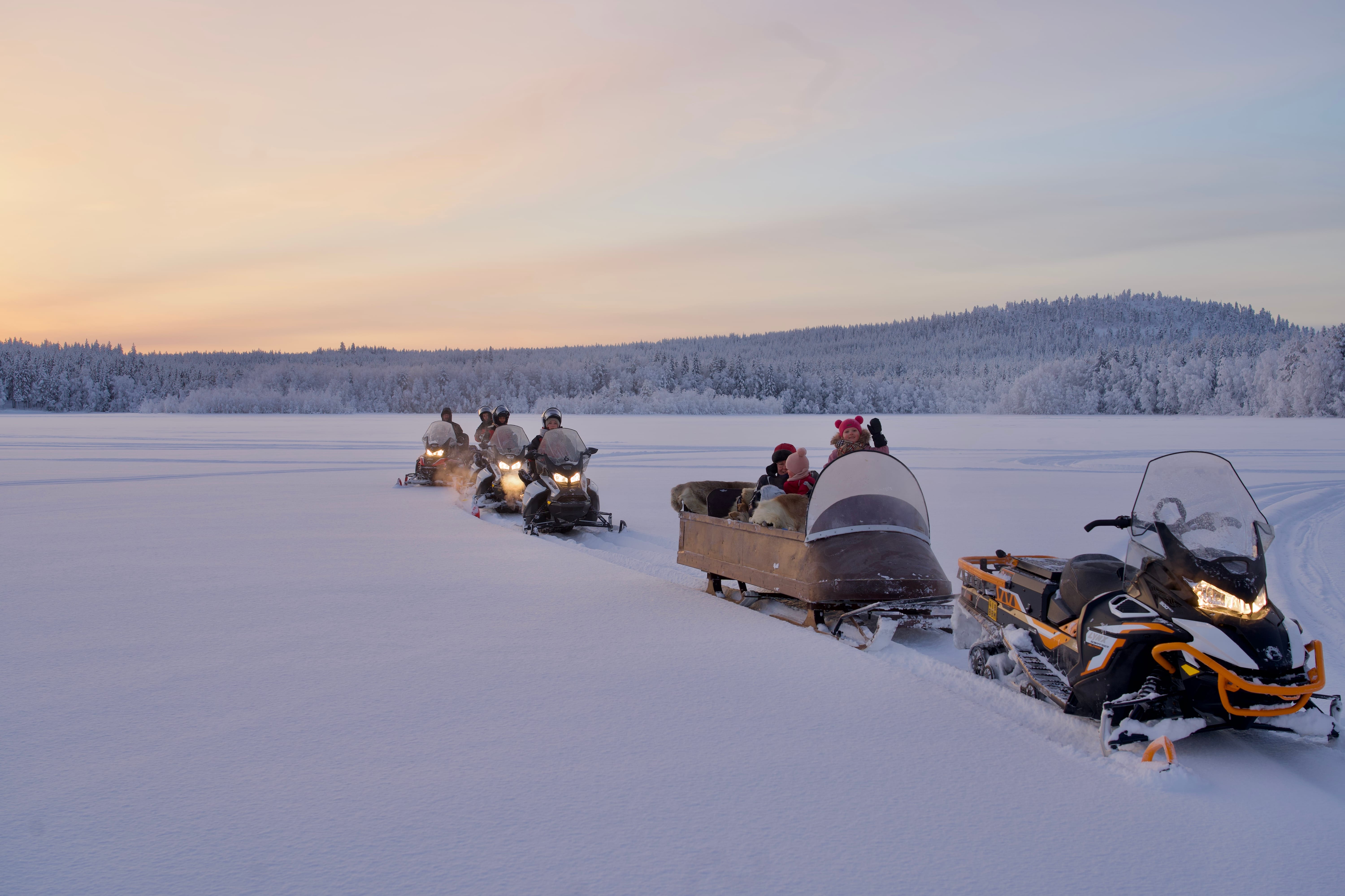 Snowmobiles driving through the snow-covered trails of Rovaniemi with StayLapland.