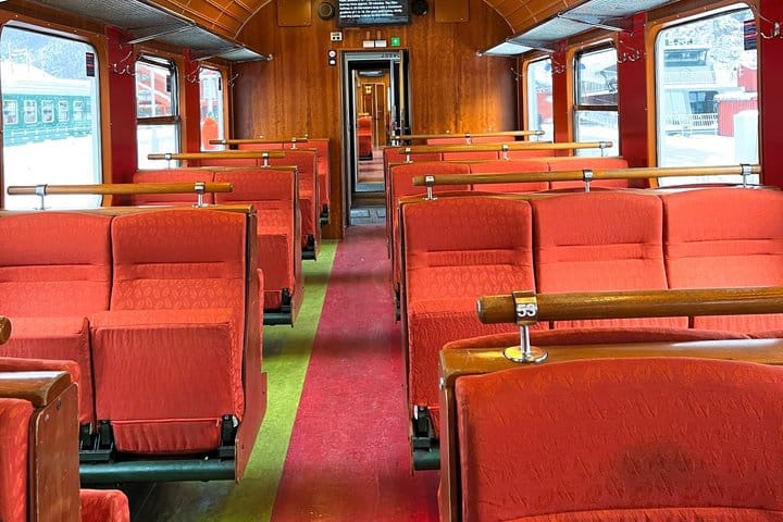 Red upholstered seats inside a vintage Flåm Railway carriage