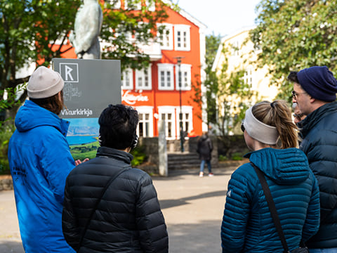 Group standing together while listening to a guide
