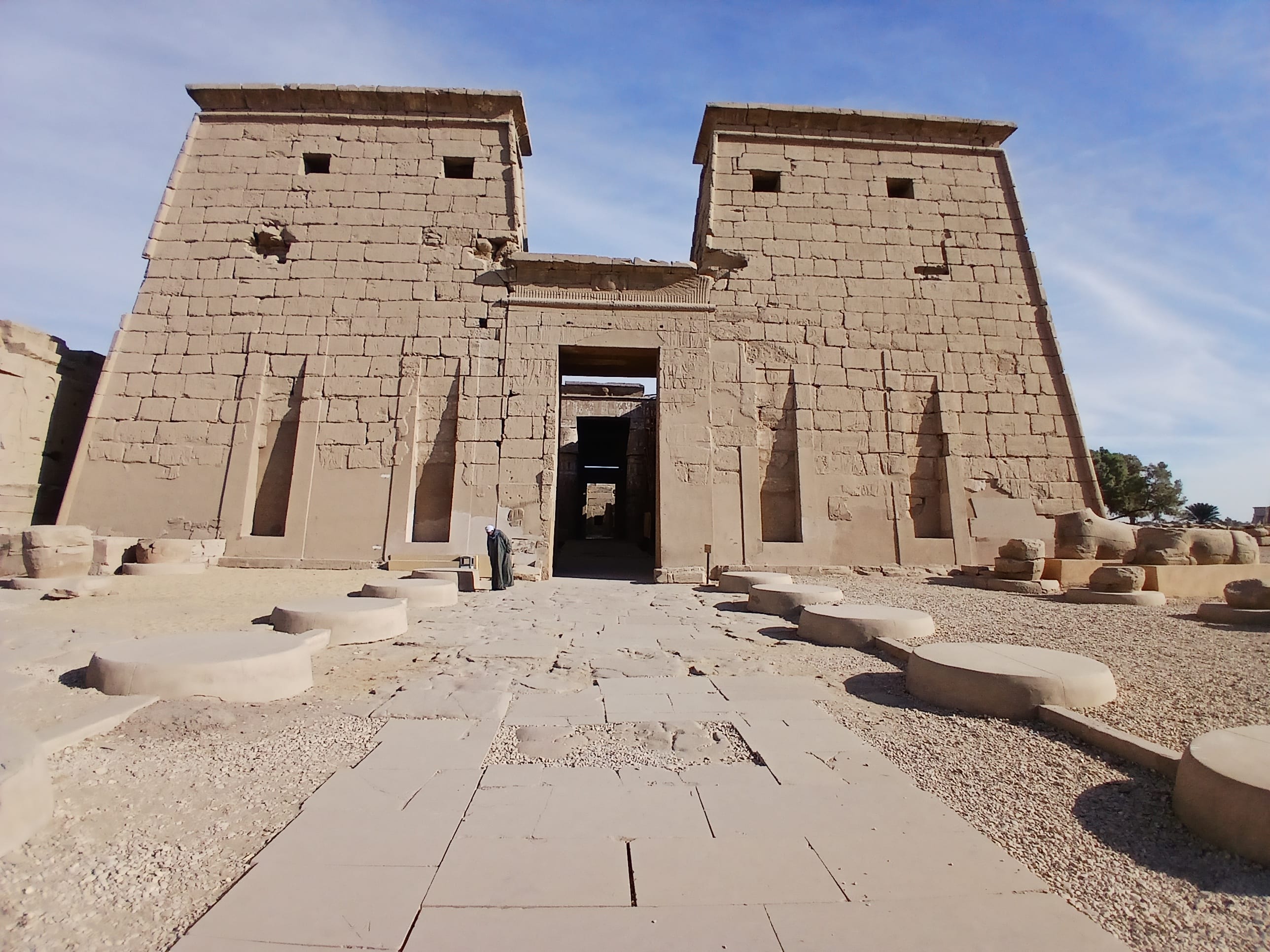 A wide stone pathway leading to the massive carved pylon gate of Khonsu Temple