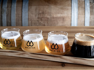 A picture of 4 different spirits in glasses ready to be sampled.