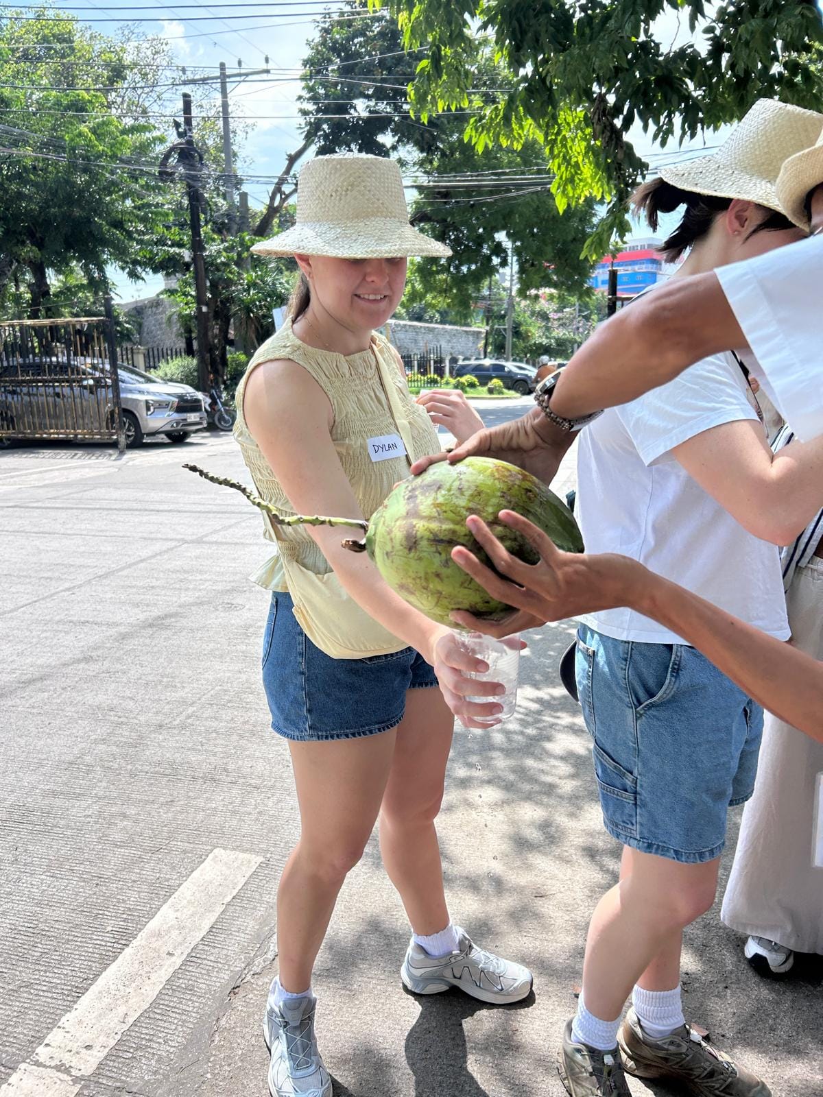 A traveller taste fresh coconut water served from a whole green coconut during the Cebu tour. Availability depends on freshness..