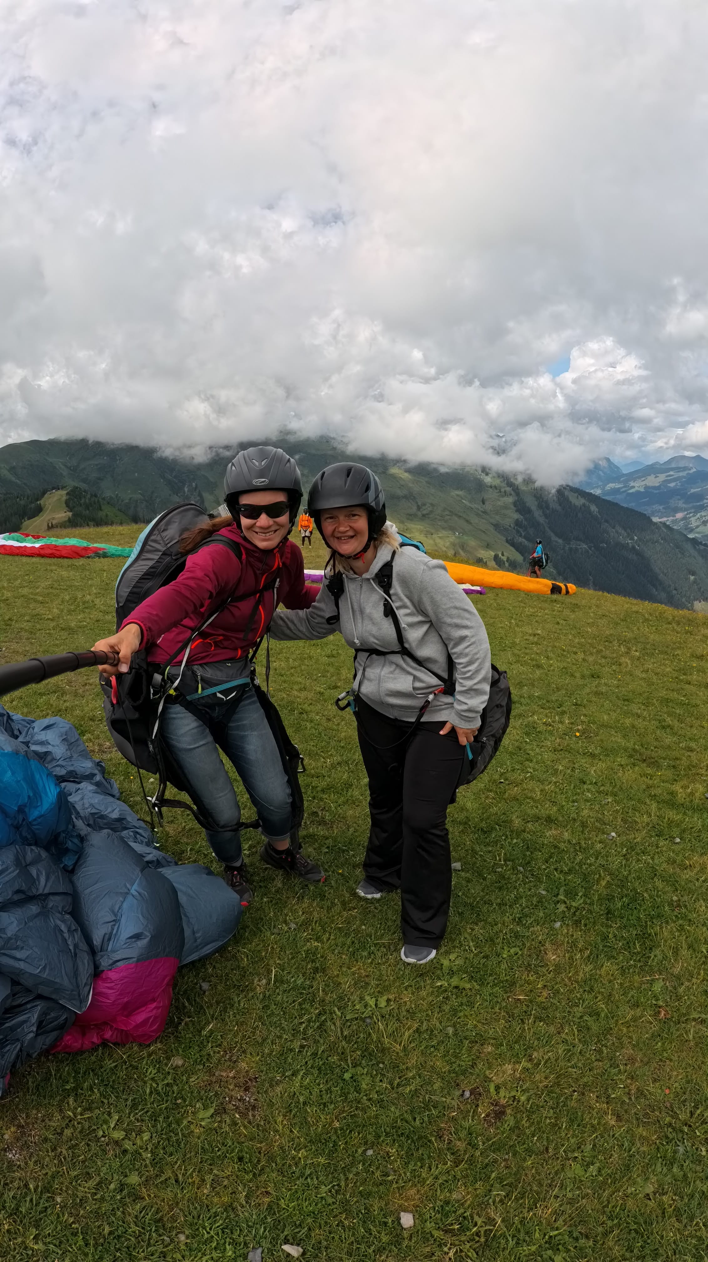 Tandem pilot giving pre-flight briefing before paragliding flight and making selfie