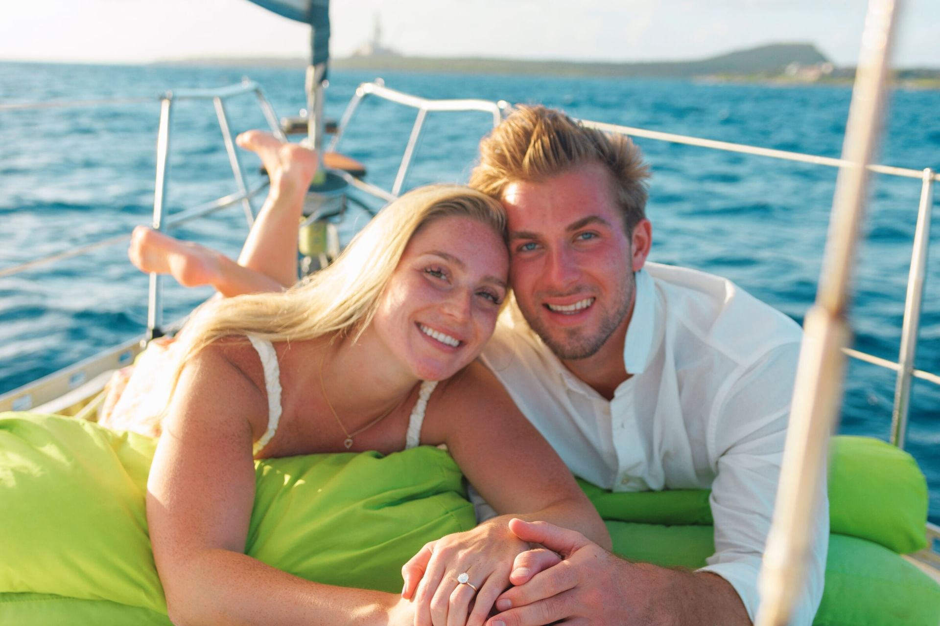 Happy couple celebrating engagement at sunset on sailing yacht with Maxie Sailing Curacao