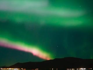 Spectacular Aurora Borealis display over the ocean near Reykjavík