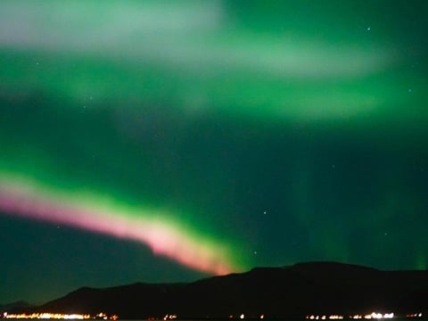 Spectacular Aurora Borealis display over the ocean near Reykjavík