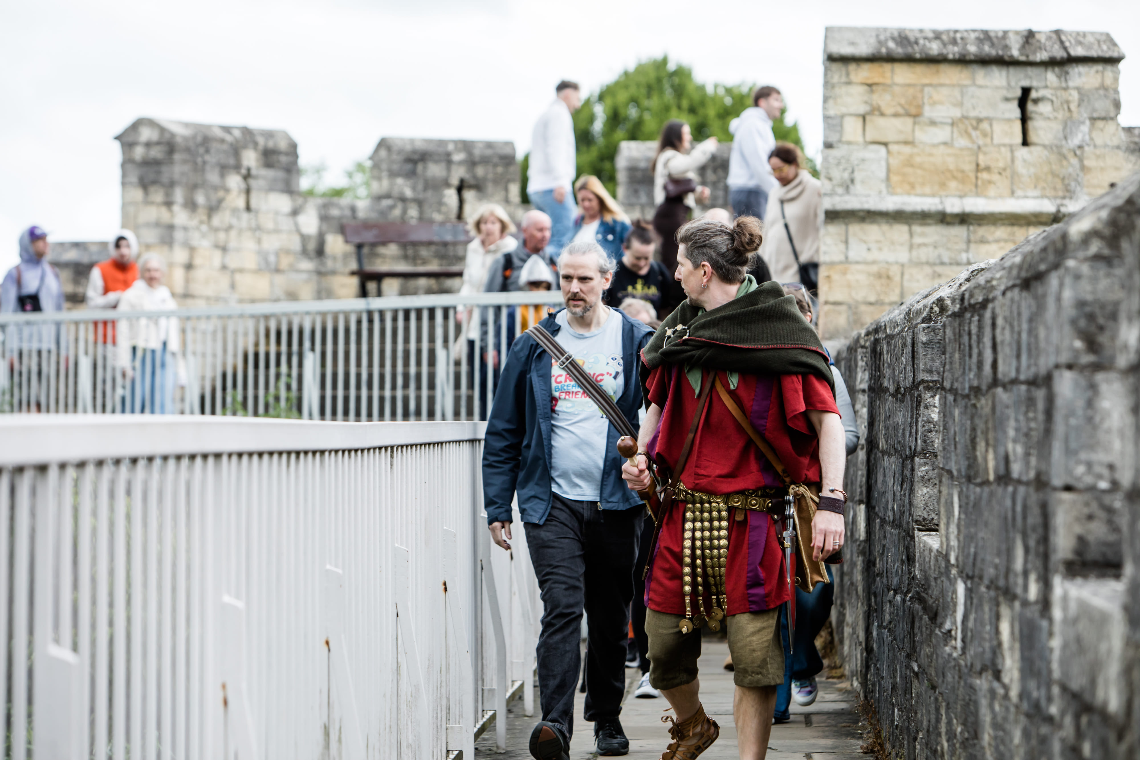 A Roman legionary walks along York city walls--medieval walls built on top of the Roman original. Behind him is the Robin Hood Tower, York.