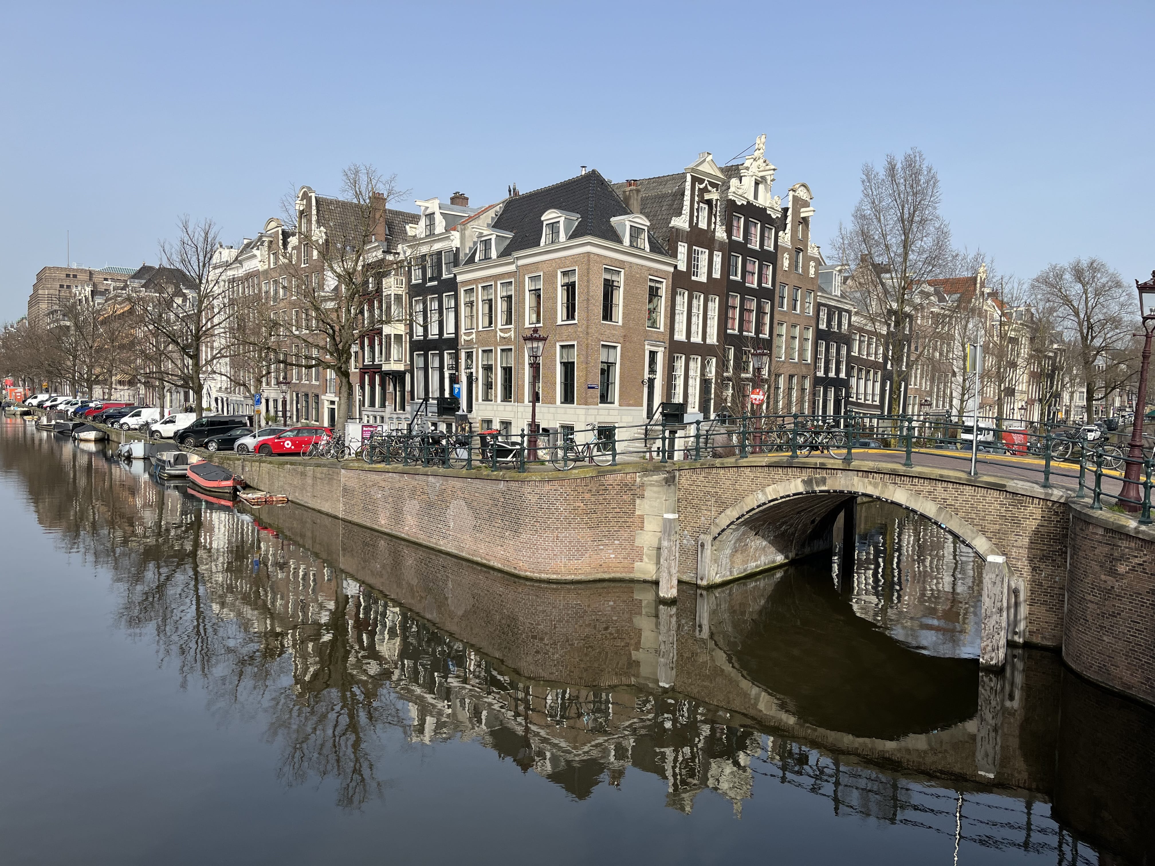 Amsterdam canal bridge with historic houses during private hop-on hop-off sightseeing tour