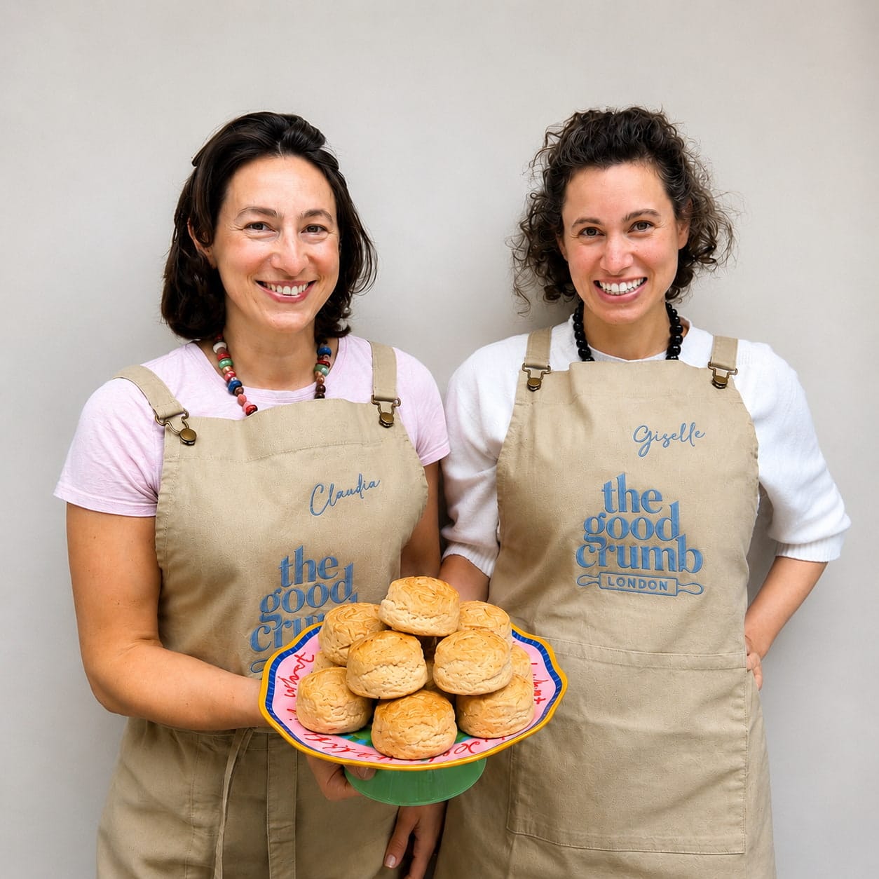 Your hosts, two women named Claudia and Giselle, holding a plate of scones