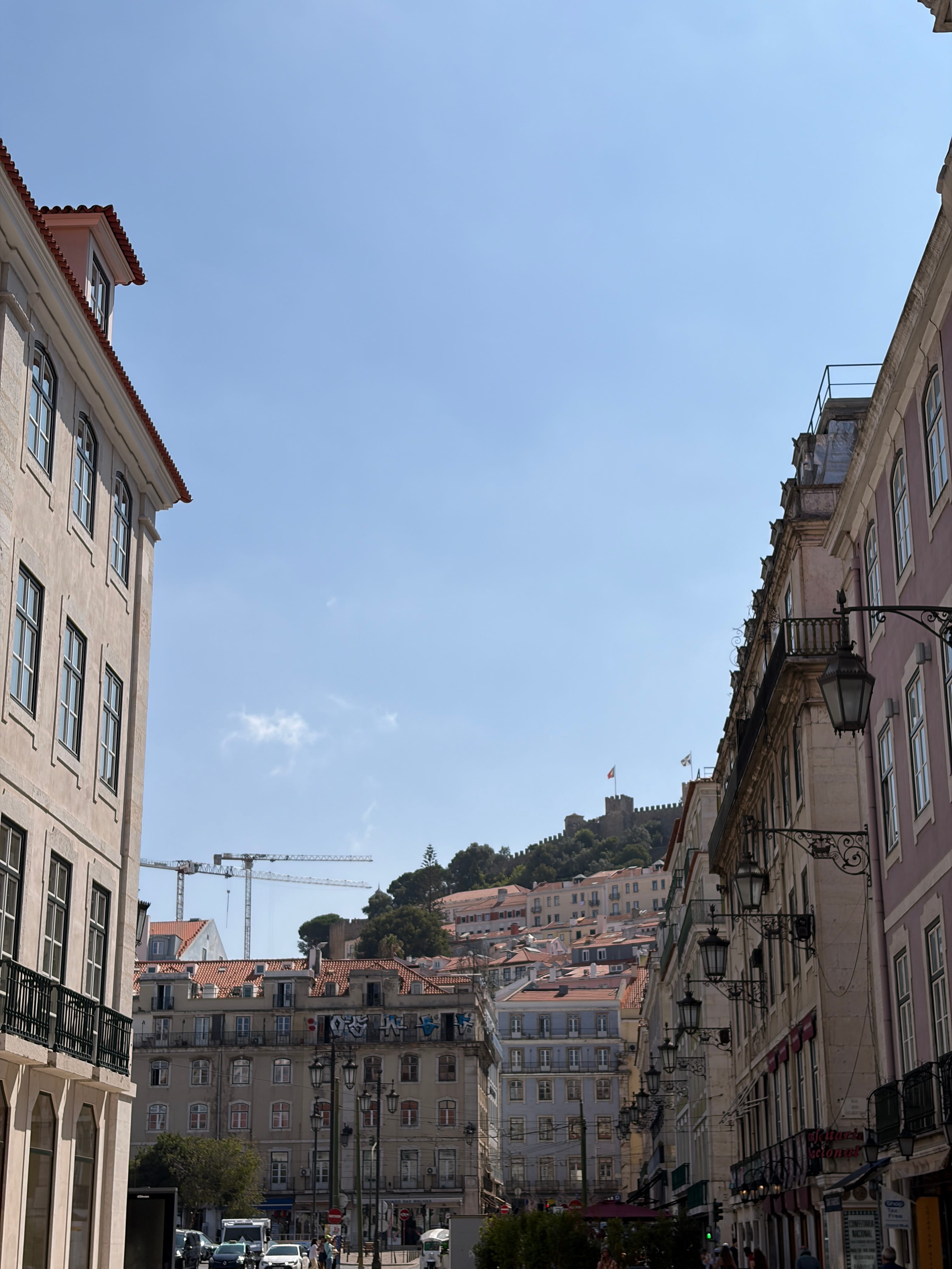 Tourists exploring the authentic cobblestone streets and colorful houses of Alfama, Lisbon's oldest district